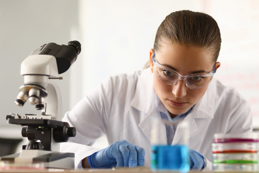 Science student in class near a microscope