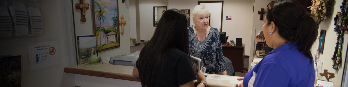 Image of a Business Office clerk interacting with a student and their parent.