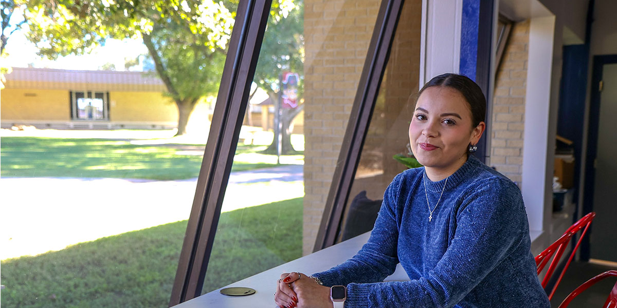 Image of a student standing near a window.