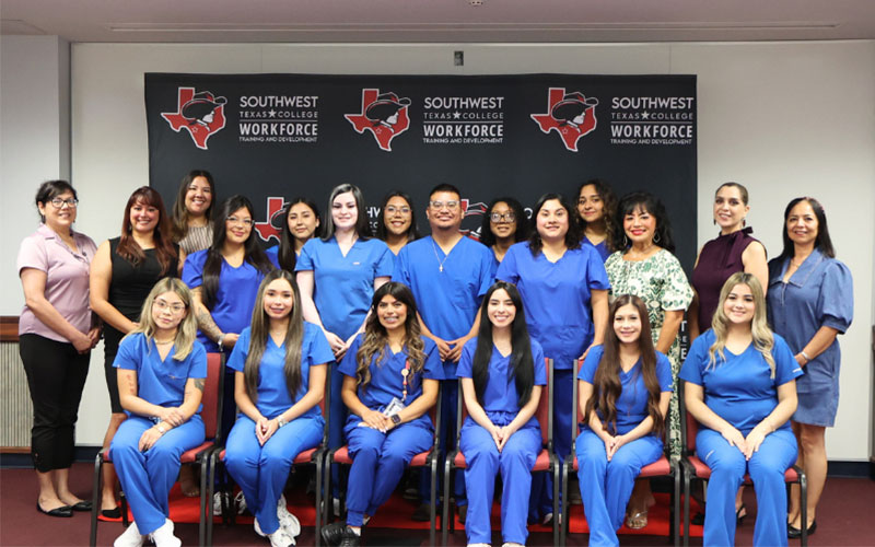 Inaugural Dental Assistant graduates pose in front of an SWTX logo background alongside Instructor Jessica Orona and Workforce Training & Development staff at the July 2026 ceremony.